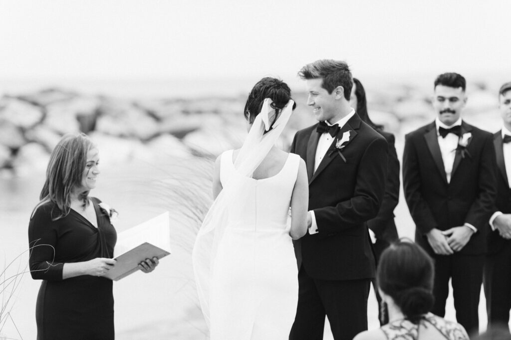 Ceremony on the beach at Rosewood Beach in Highland Park with groom smiling