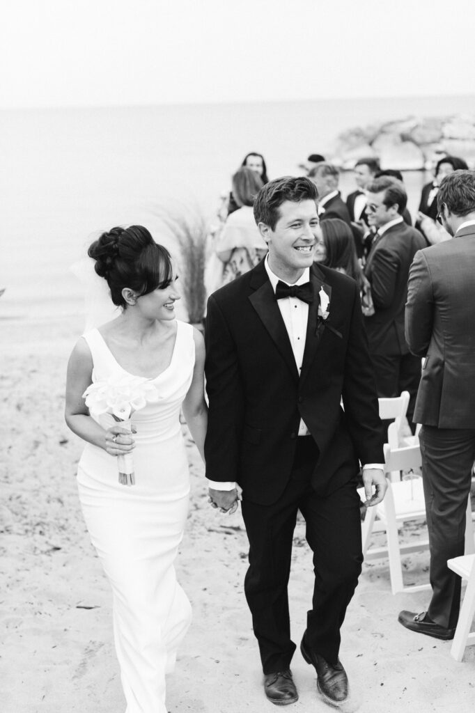 Bride and Groom walking back during the recessional on the beach at Rosewood Beach in Highland Park