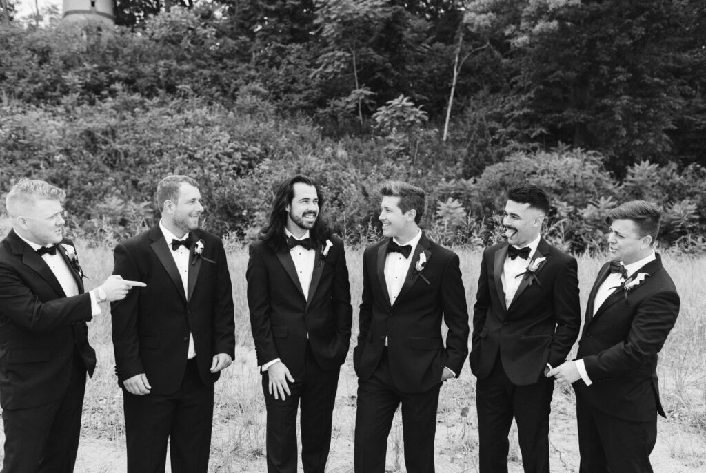 Groom and Groomsmen talking and smiling on the beach at Rosewood Beach in Highland Park