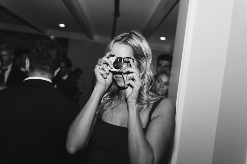 Wedding guest taking a photo with a disposable camera