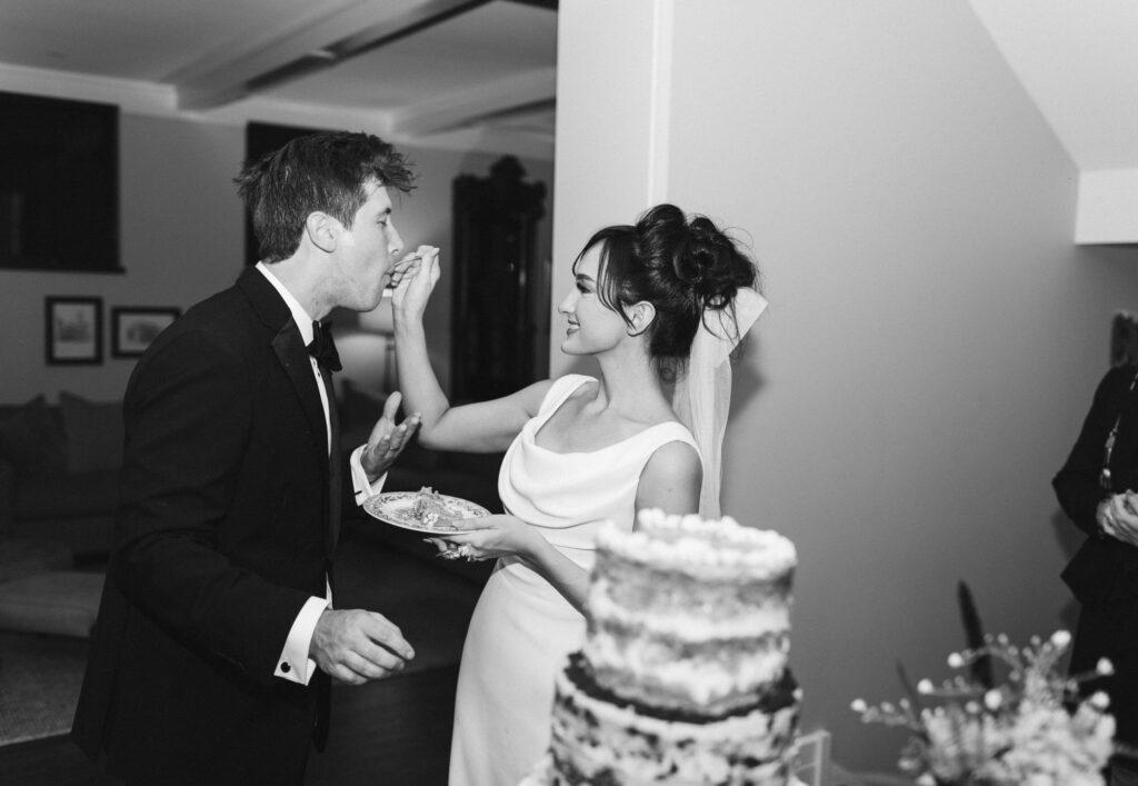Bride feeding groom a bite of wedding cake