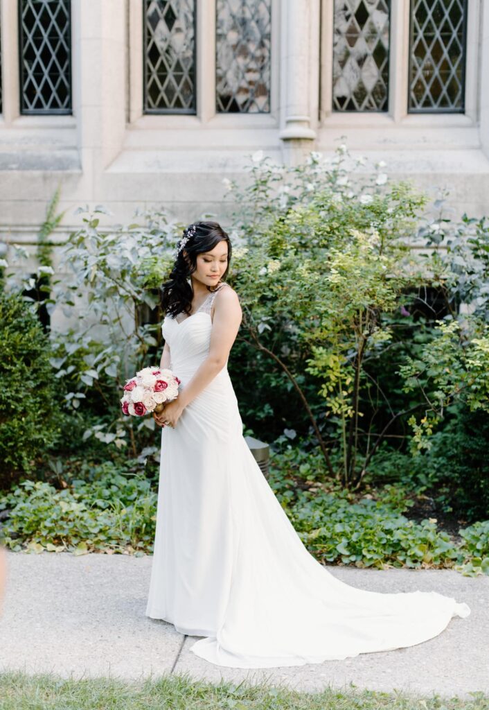 Bridal portrait of bride holding bouquet with the full length of dress on display