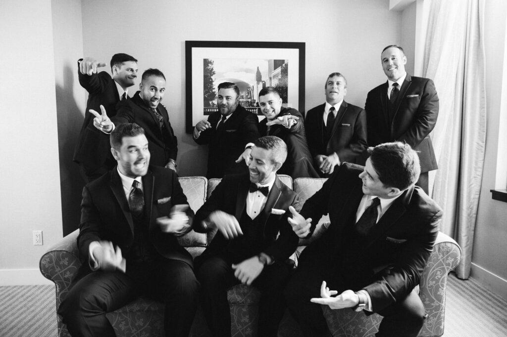 Groom and Groomsmen laughing and sitting on a couch