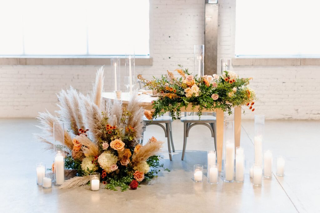 Reception sweetheart table decor with candles and florals