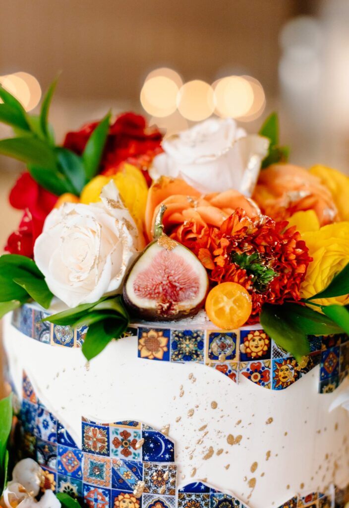 Close up of wedding cake and tile details with florals