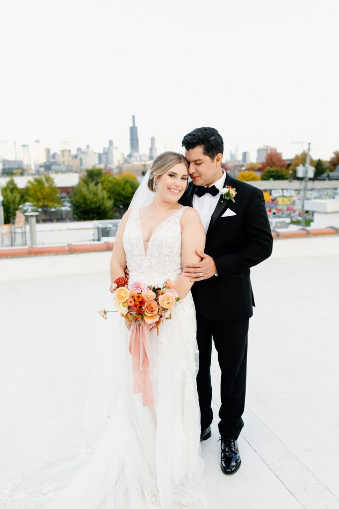 Bride and Groom leaning into each other showing full body on the roof top