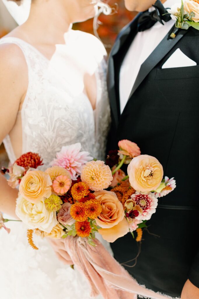 Close up of the bouquet while bride holds it close to the Groom