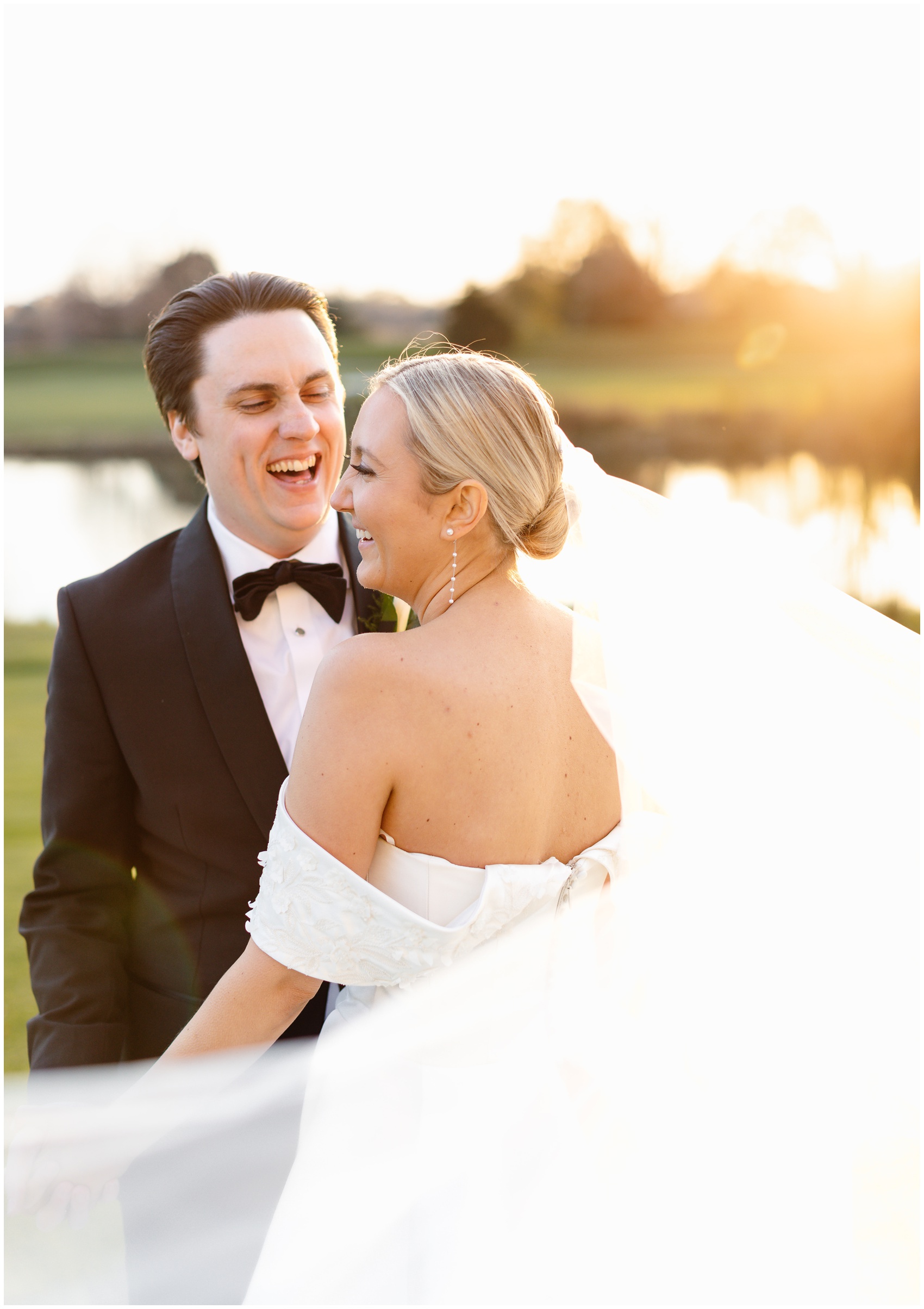 A bride and groom hold hands and laugh while walking on the golf course at sunset at their Hyatt Lodge Oak Brook Wedding