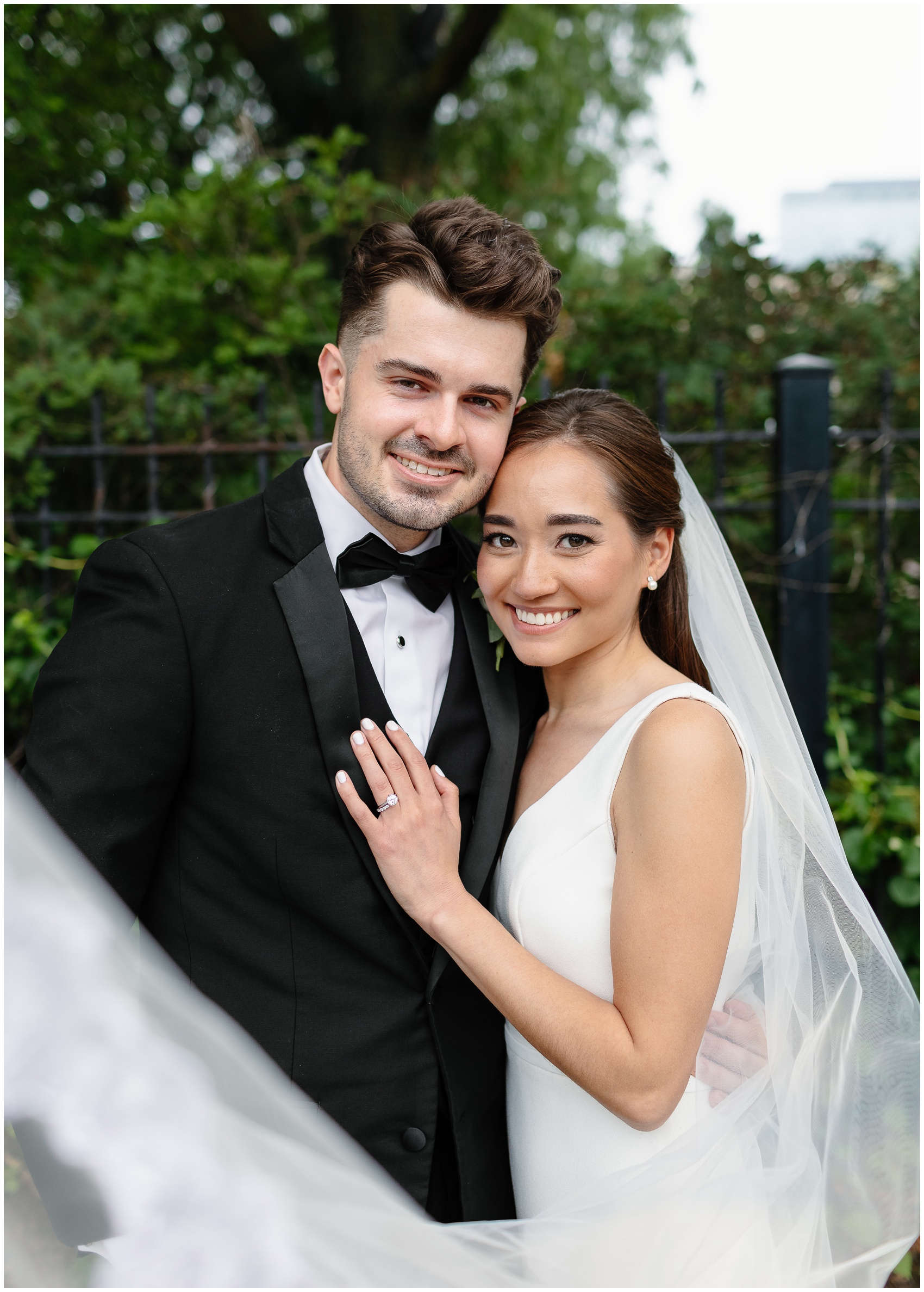 Newlyweds lean onto each other while hugging in a garden at their wedding at the arbory chicago