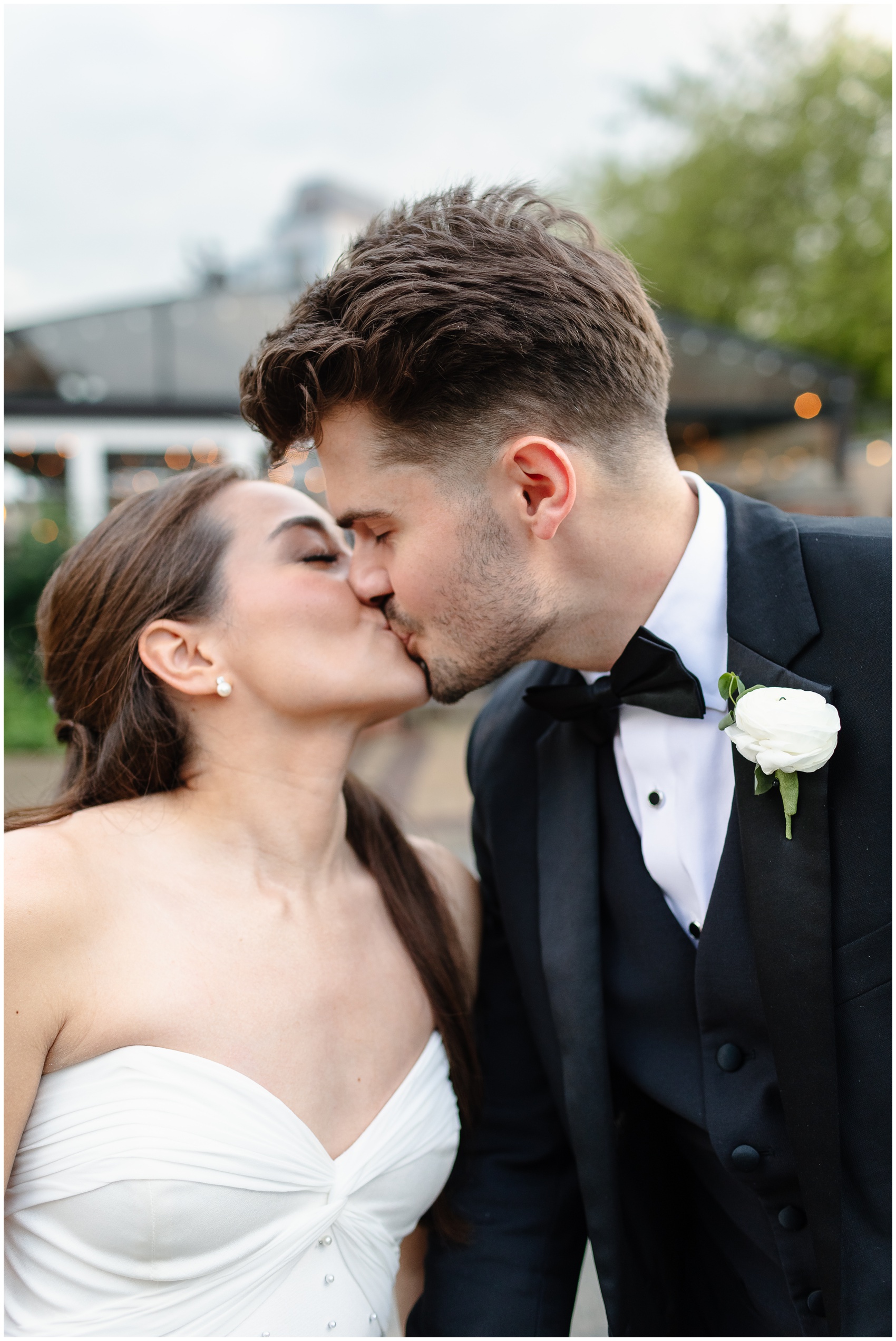 Newlyweds kiss while walking outside their reception at the arbory chicago