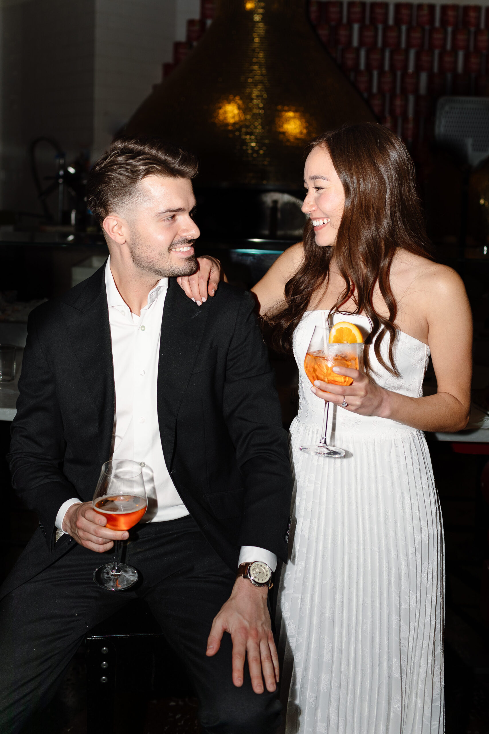 Couple smiling at each other while having drinks during photo session