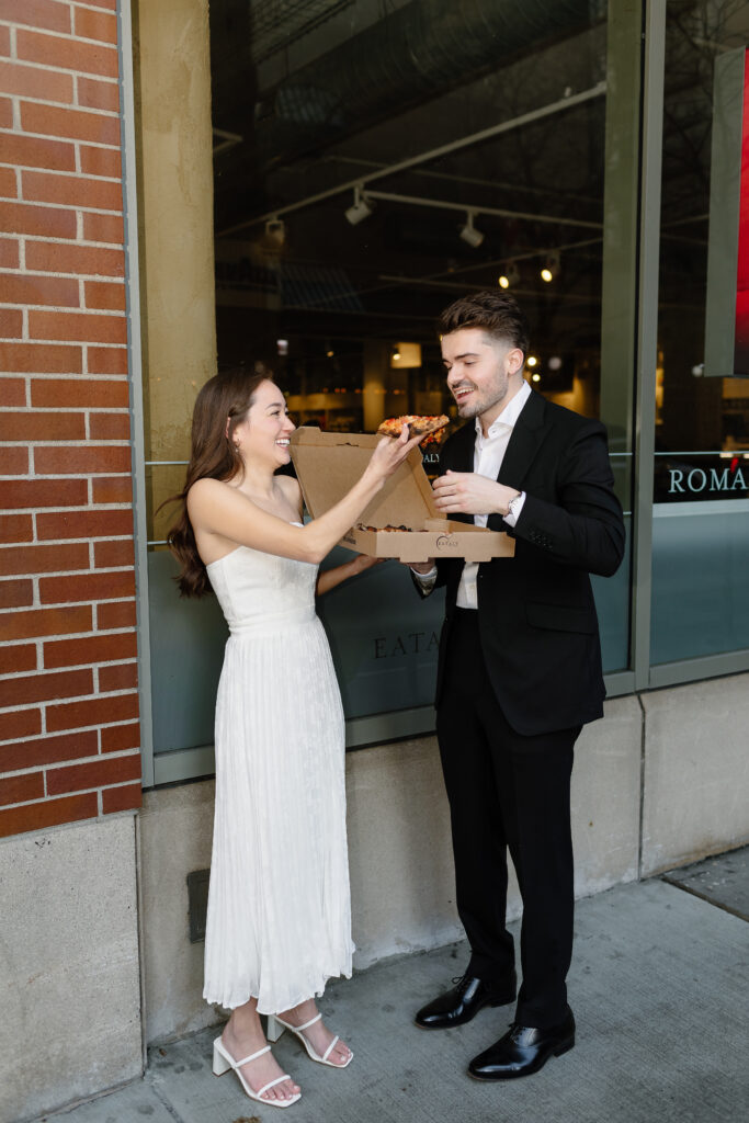 Couple smiling while eating pizza downtown chicago