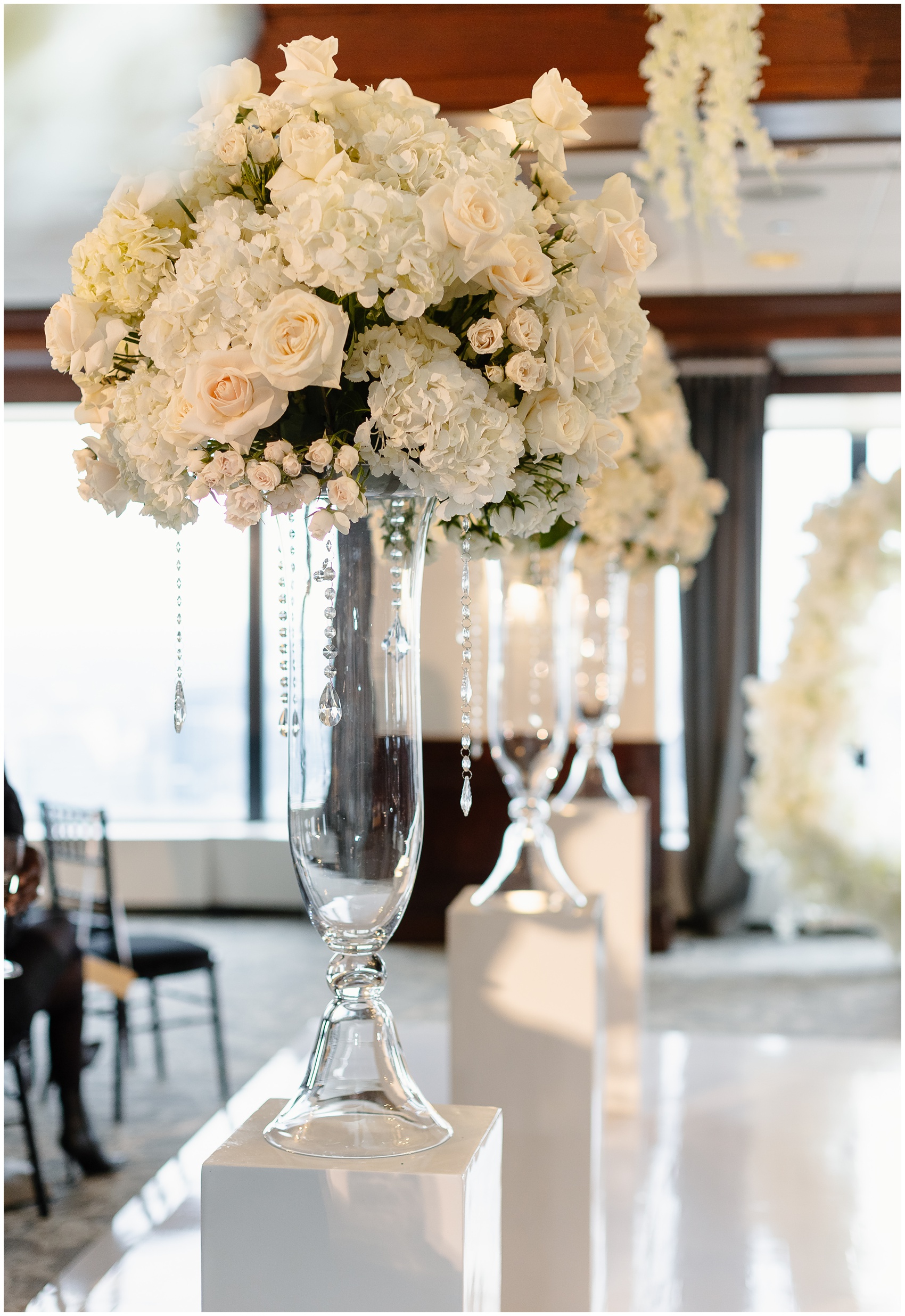 Details of a tall white flower bouquet on a pedestal on the dance floor