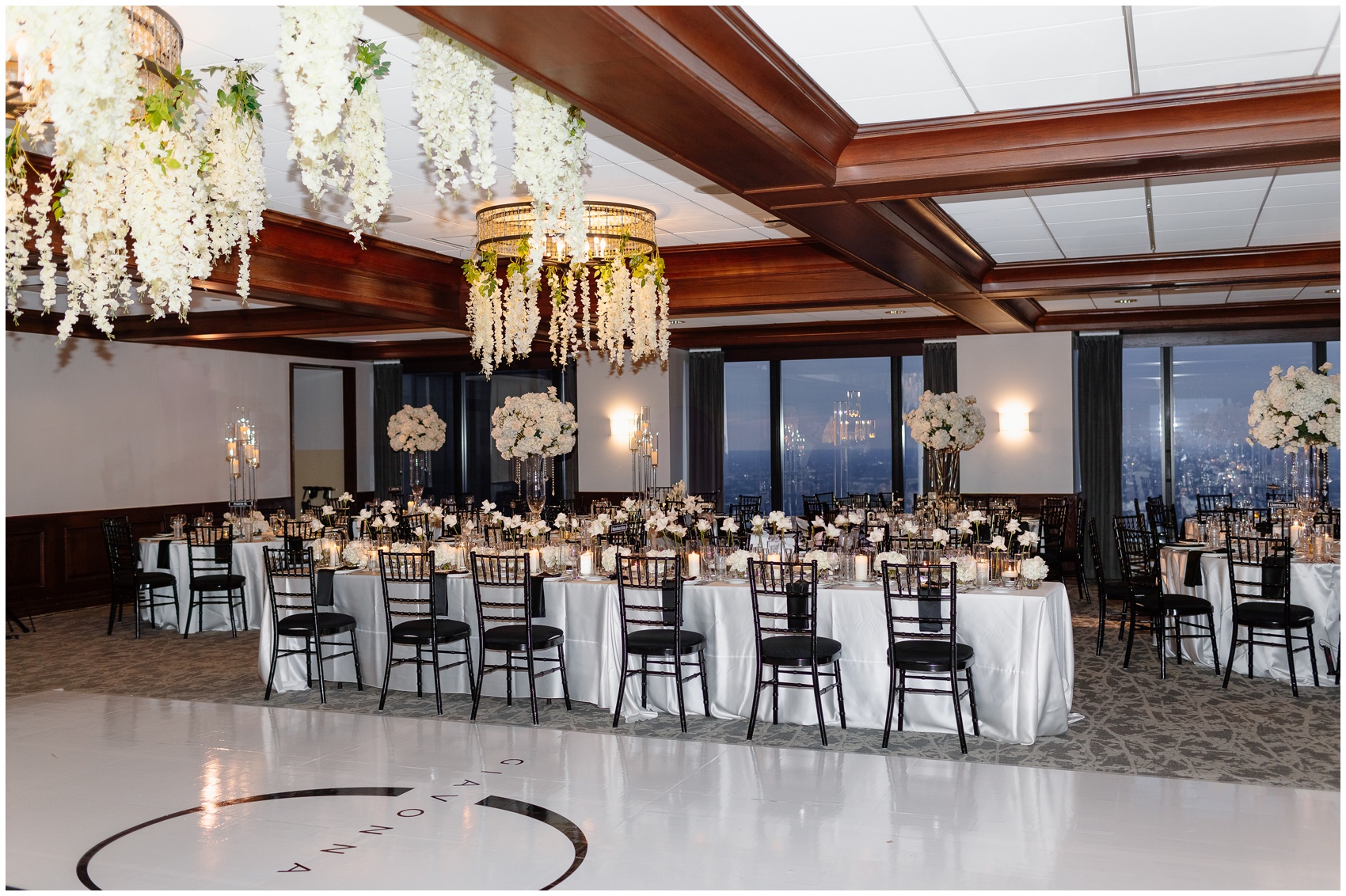 Details of a dance floor and wedding reception set up with hanging white flowers on chandeliers designed by Chicago Wedding Planners