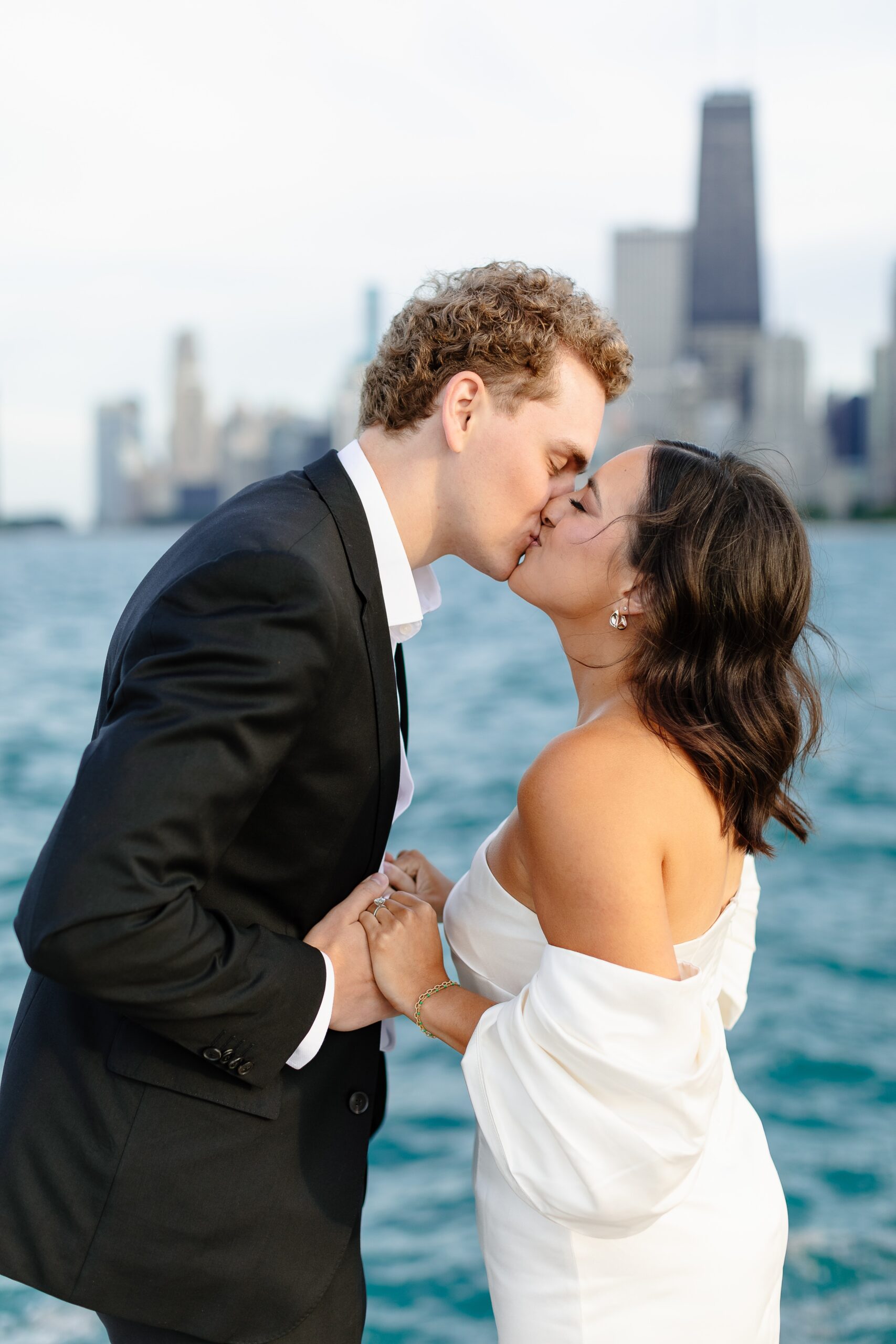 A happy engaged couple kisses while overlooking the water at one of the stunning engagement photo locations chicago