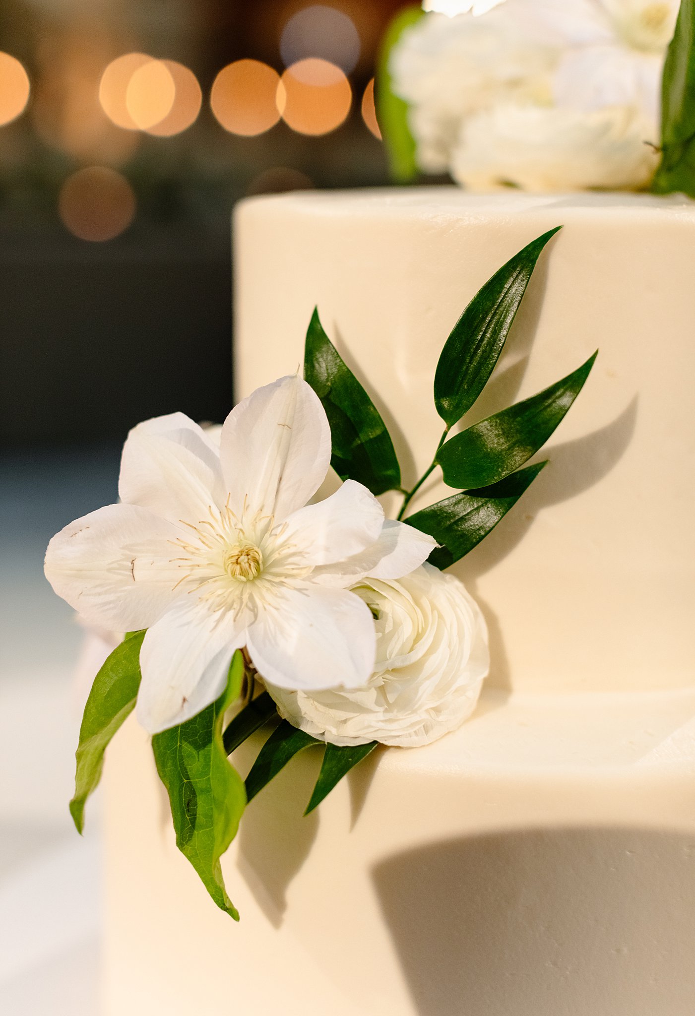 Details of a white flowers on a white cake for a wedding