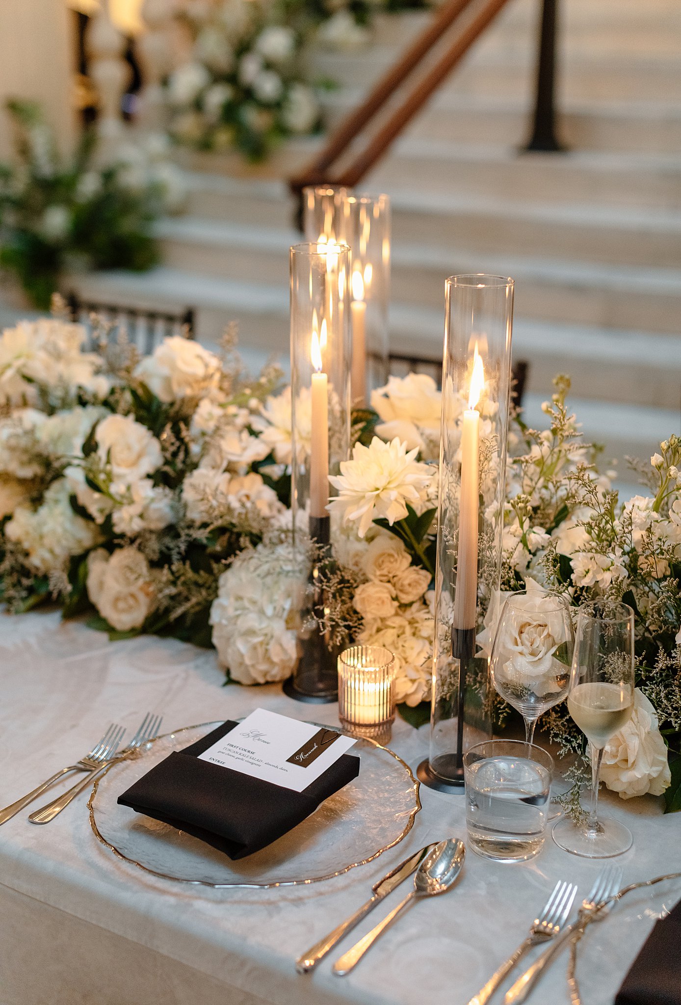 Details of a table setting with white roses, candles and black napkin at one of the Downtown Chicago Wedding Venues