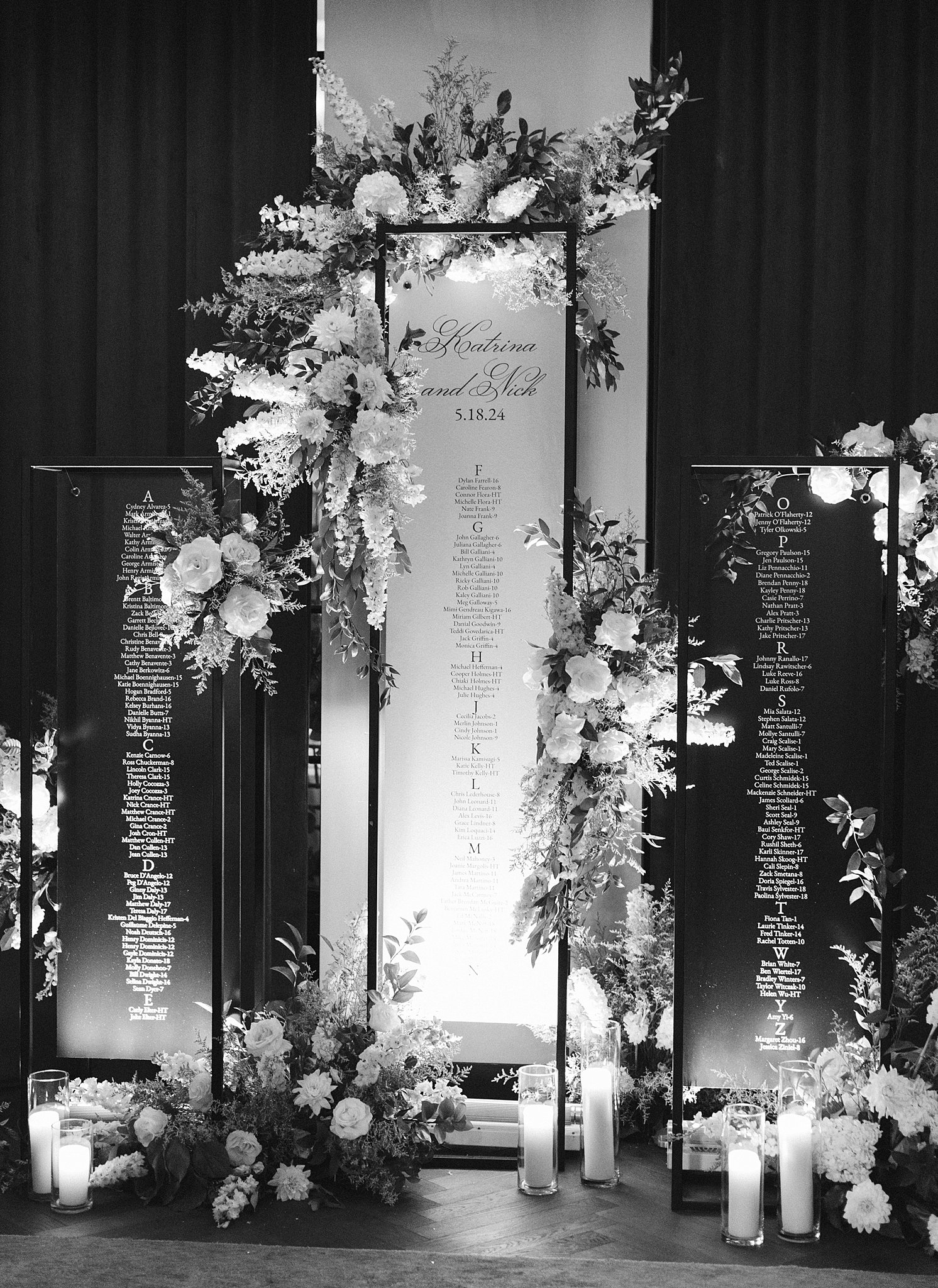 Details of tall glass wedding reception seating assignments with flowers and candles at one of the Downtown Chicago Wedding Venues