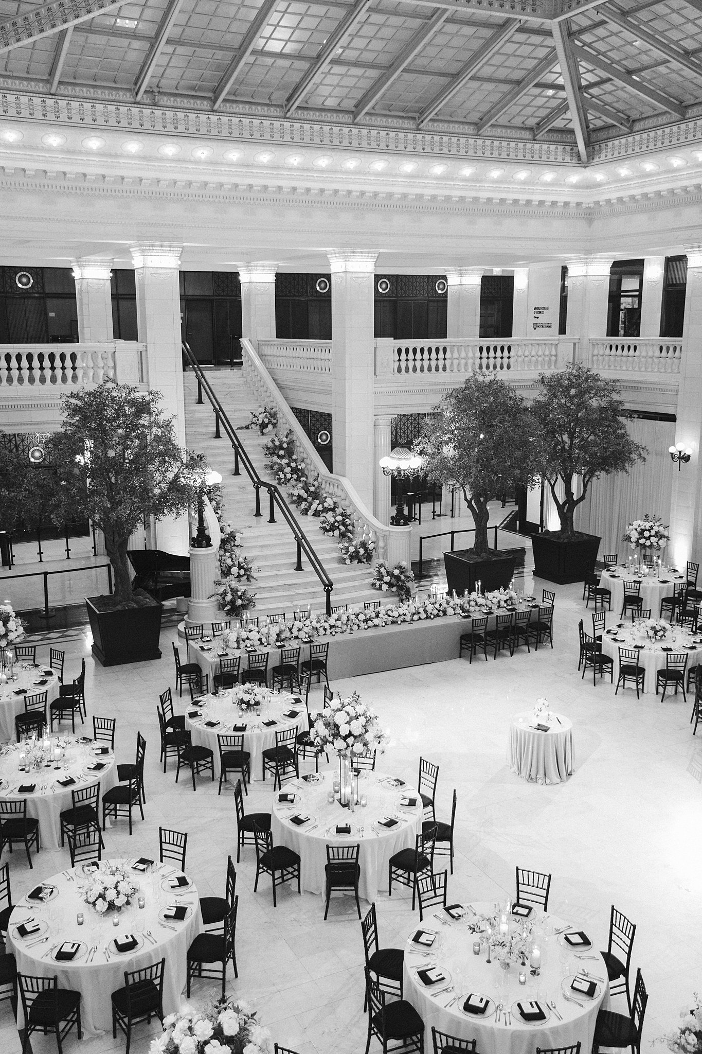 A black and white image of a Downtown Chicago Wedding Venue reception ballroom set up with florals and round reception tables