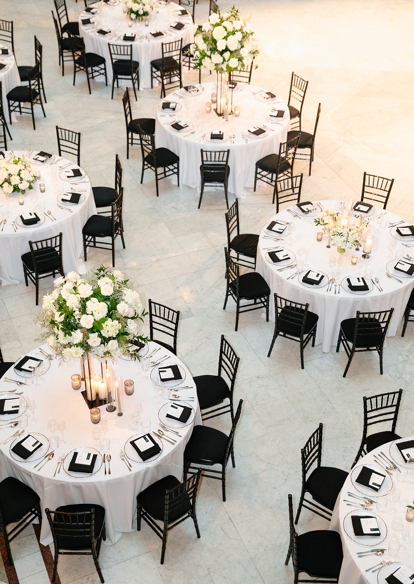 A look down onto round reception table set up with white linen and black chairs at one of the Downtown Chicago Wedding Venues