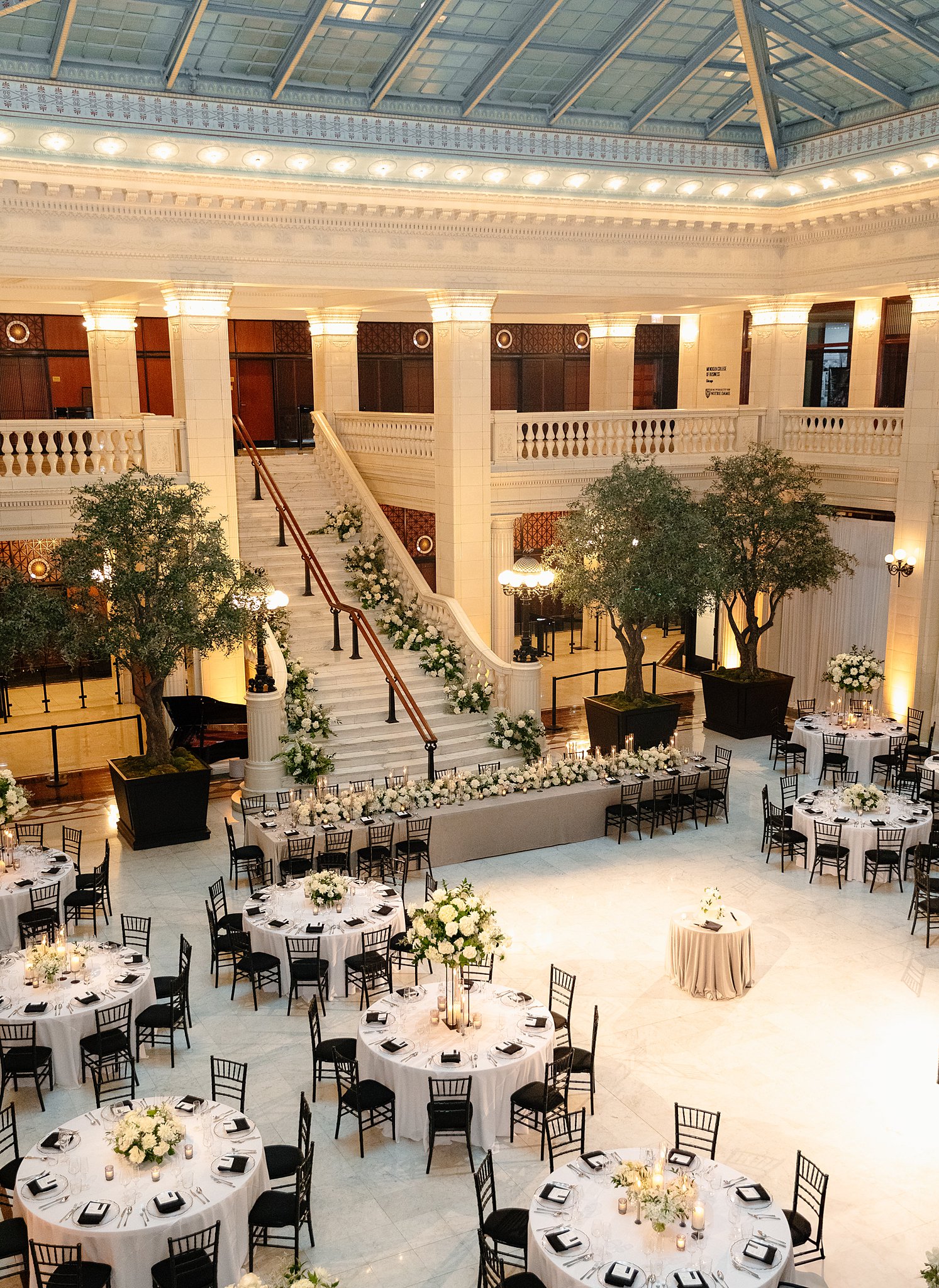 A Downtown Chicago Wedding Venue set up for a reception with epic staircase and white florals