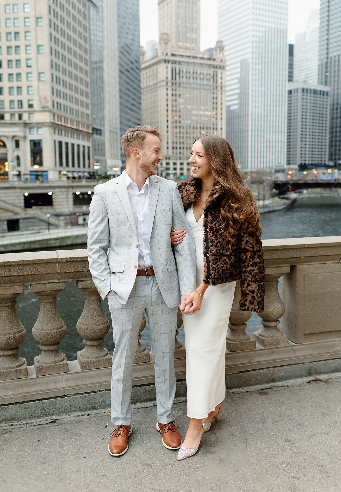 A couple explores a romantic walk on a bridge holding hands