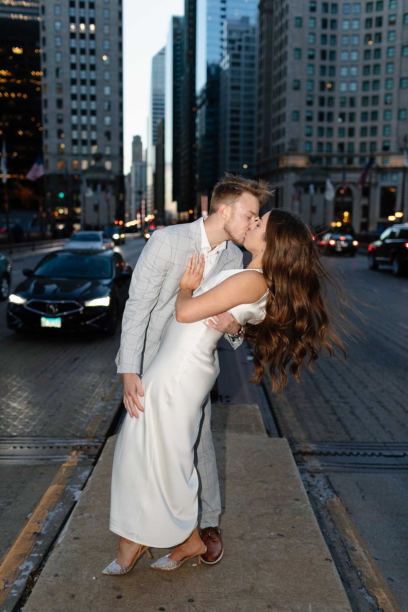 Newly engaged couple kiss dramatically in the street during their winter engagement photos in chicago