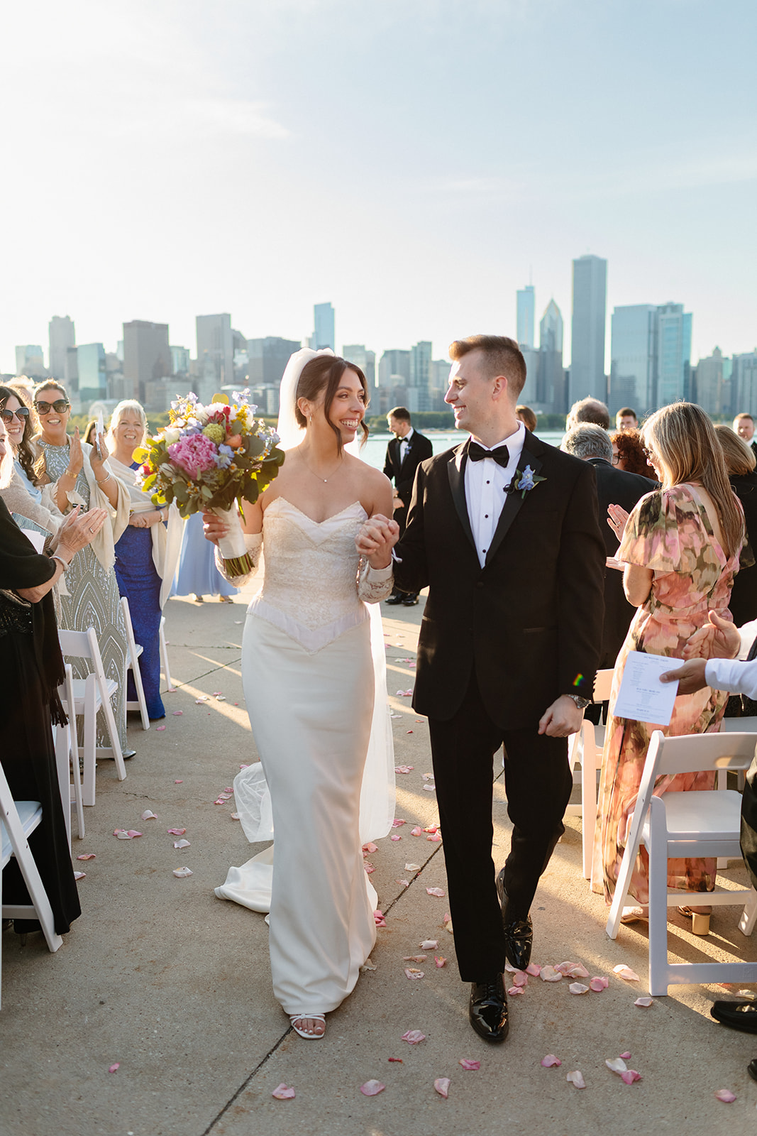 a just married couple smiles as they walk down the isle